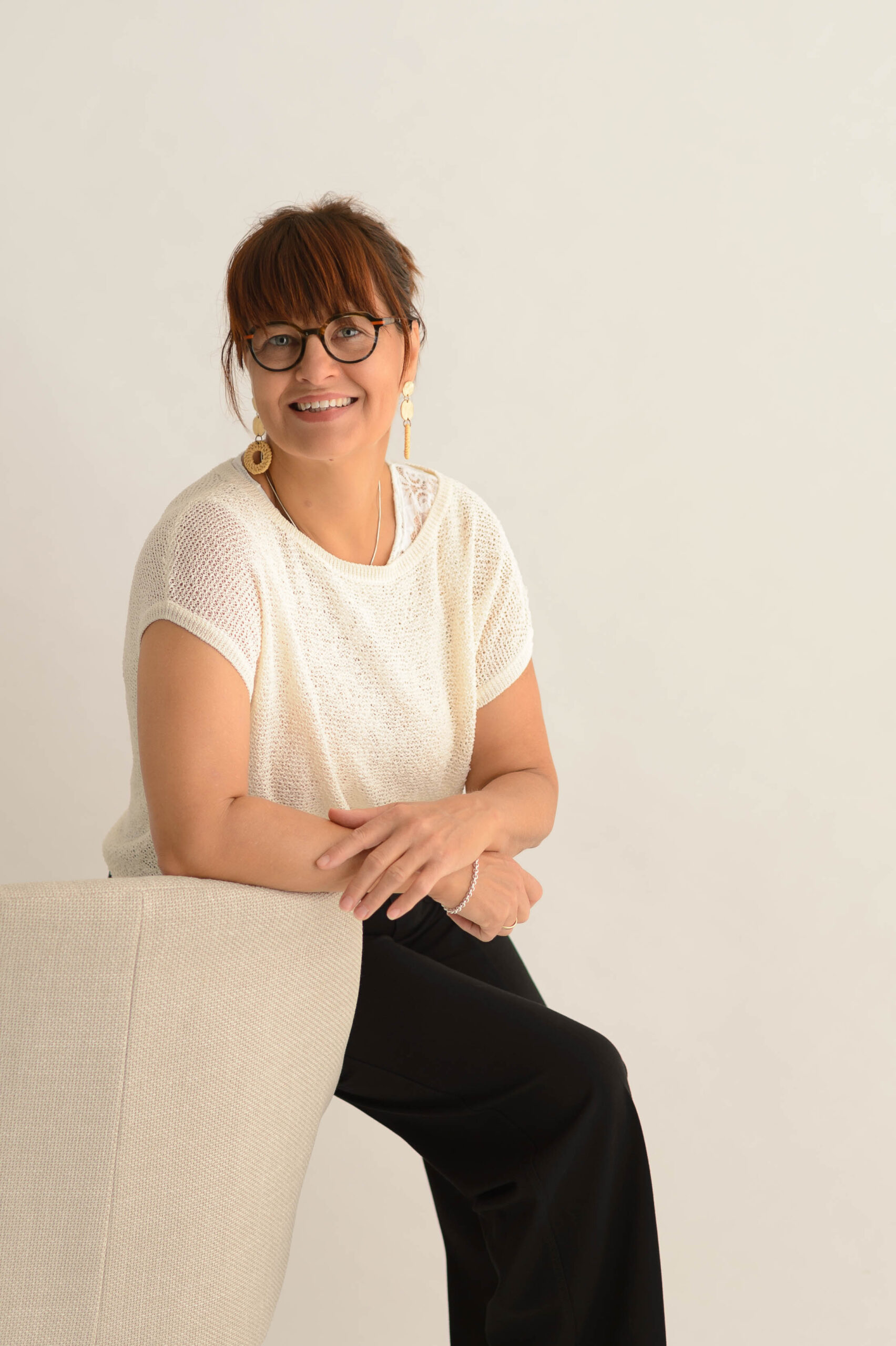 die Fotografin Susanne Söder sitzend auf einem weißen Sessel