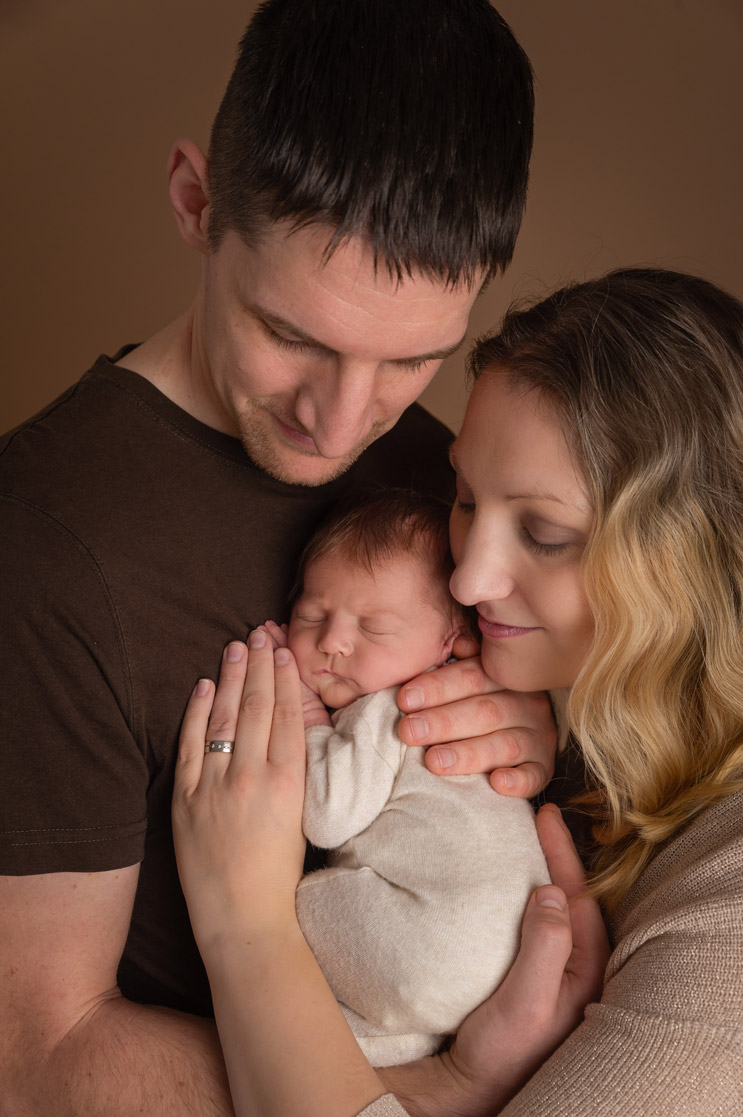 Eltern kuscheln mit Babymädchen Neugboernenfotografie