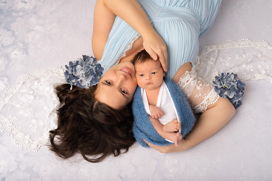 Mama im Blauen Kleid liegend mit Neugeborenen am Kopf